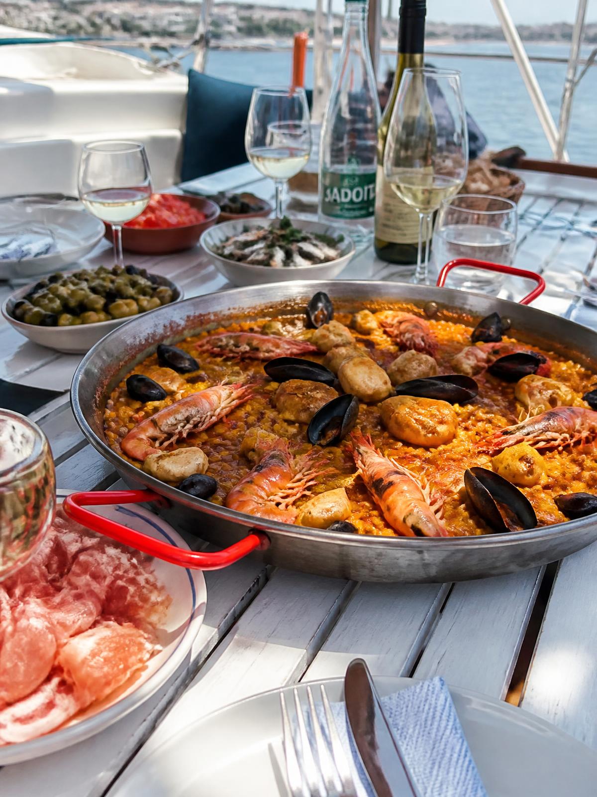 Paella au safran partagée sur la table du pont du Noctilio